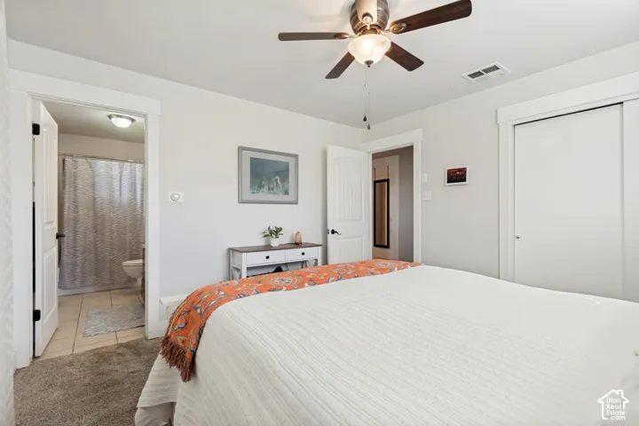Ceiling fan with integrated lighting, white interior doors, trim detailing, light grey wall paint, and sliding closet doors