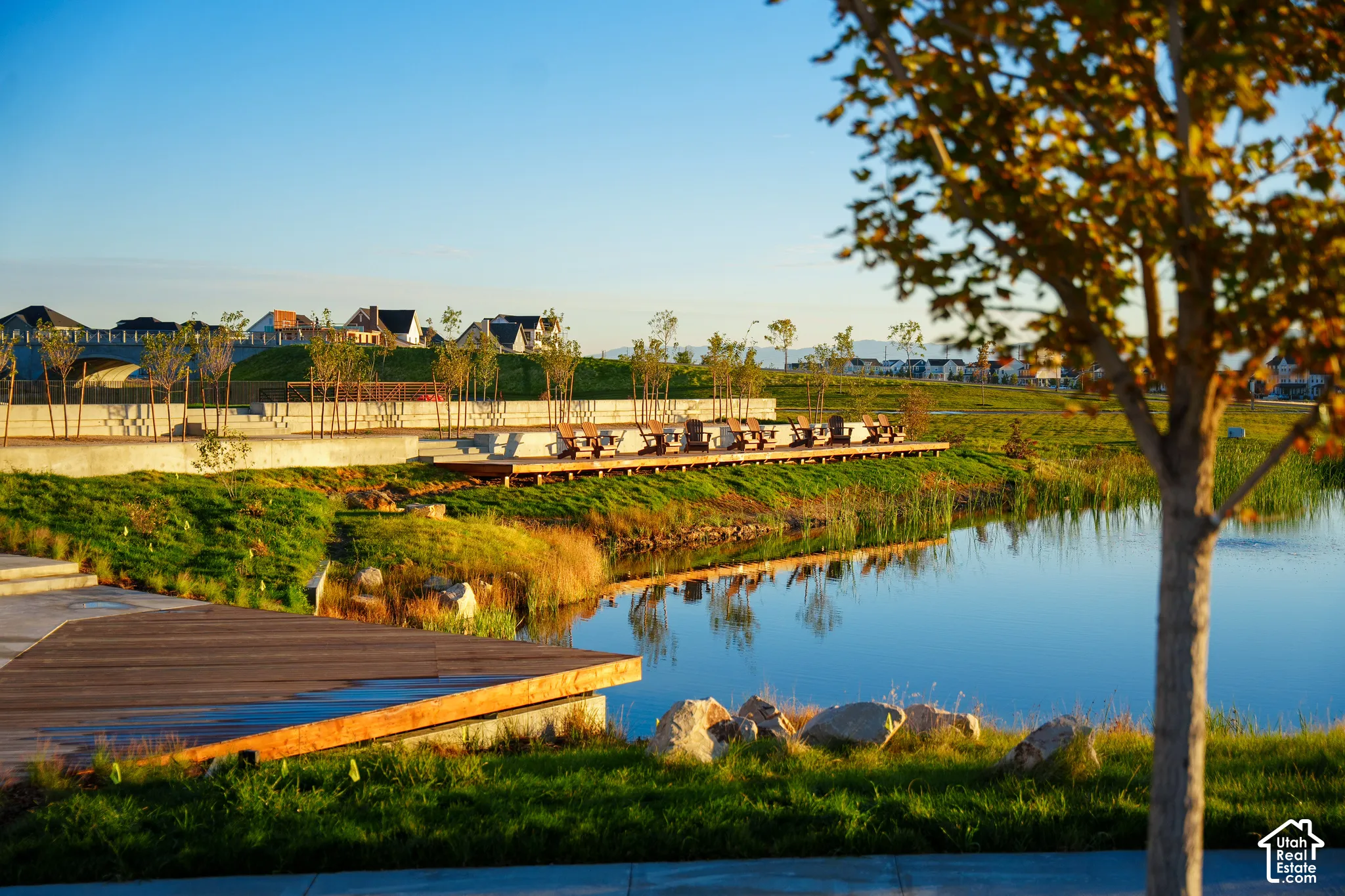 Expansive water feature with natural landscaping, boardwalk, and concrete tiered seating