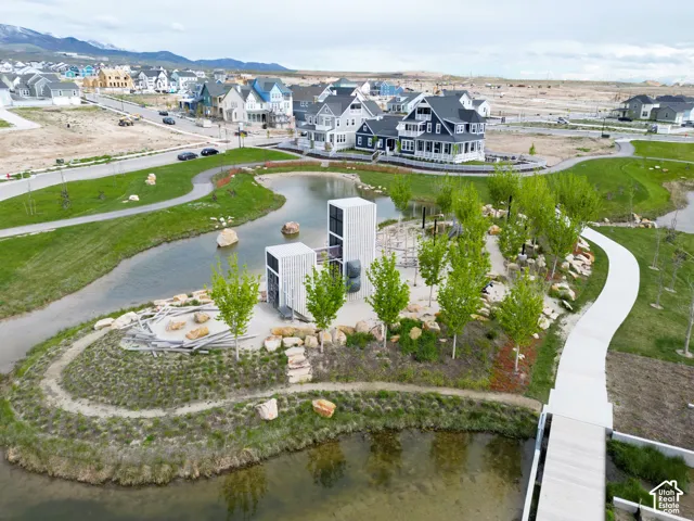 Community park featuring a pond, paved walkways, and a playground area
