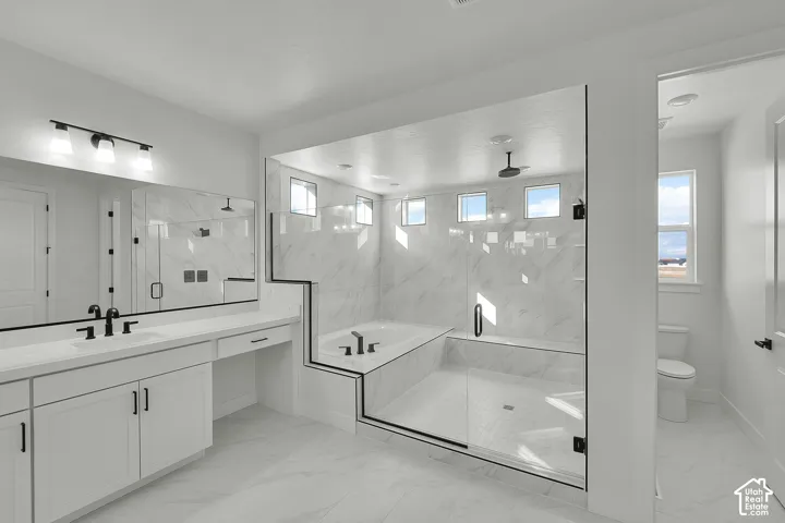 Spacious bath featuring a double vanity with ample counter space, integrated soaking tub, and a shower with a built-in bench and rain showerhead