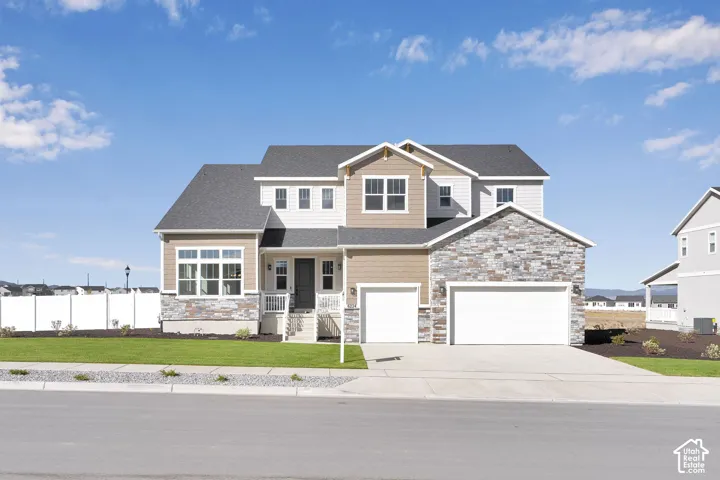 Multi-story exterior featuring a stone and siding facade, a two-car garage, and an additional single-car garage