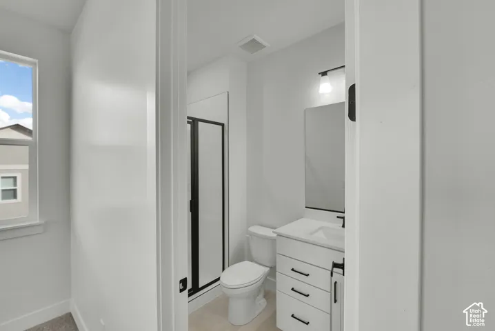 Modern bathroom featuring a white vanity with integrated sink, black hardware, framed mirror, and a shower with black-framed glass enclosure