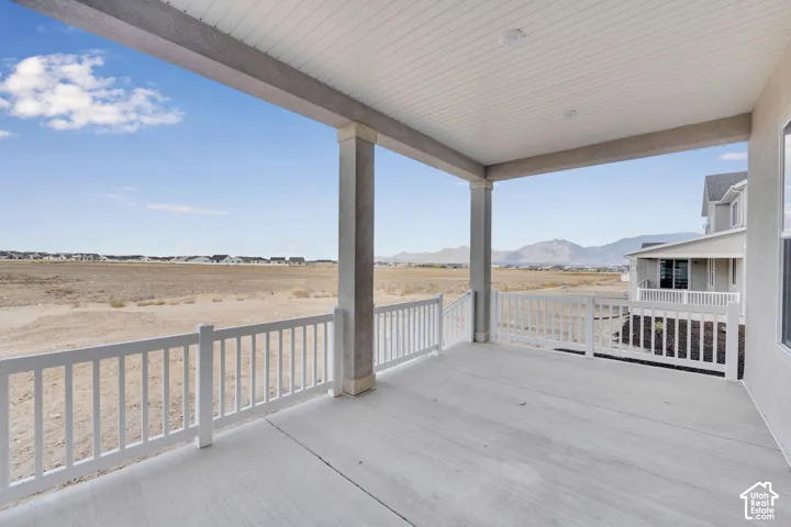 Covered concrete patio with white railing