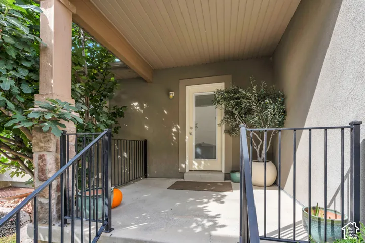 Your own private covered patio. A peaceful retreat just outside your bedroom. Outdoor patio with concrete flooring, black metal railings, and a privacy fence