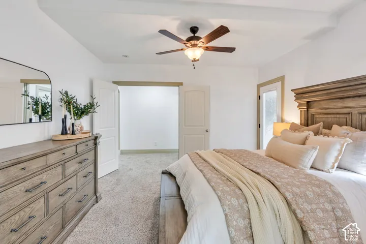 Main Level Primary Bedroom with carpet, a ceiling fan, and a glass-paneled exterior door that opens to a private covered patio. A peaceful retreat just outside your bedroom.
