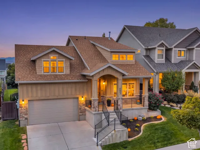 Craftsman-style 2 story HOME with stone accents, covered front porch, attached garage, dormer windows, and mature trees.