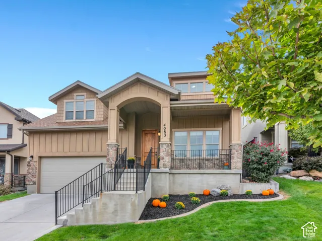 Craftsman-style 2 story HOME with stone accents, covered front porch, attached garage, dormer windows, and mature trees.
