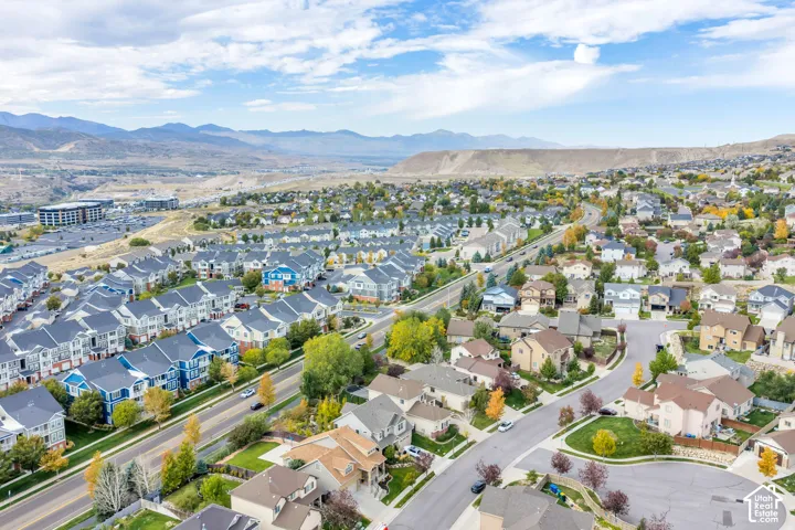 Residential area featuring diverse architectural styles, paved roadways, and surrounding natural landscapes