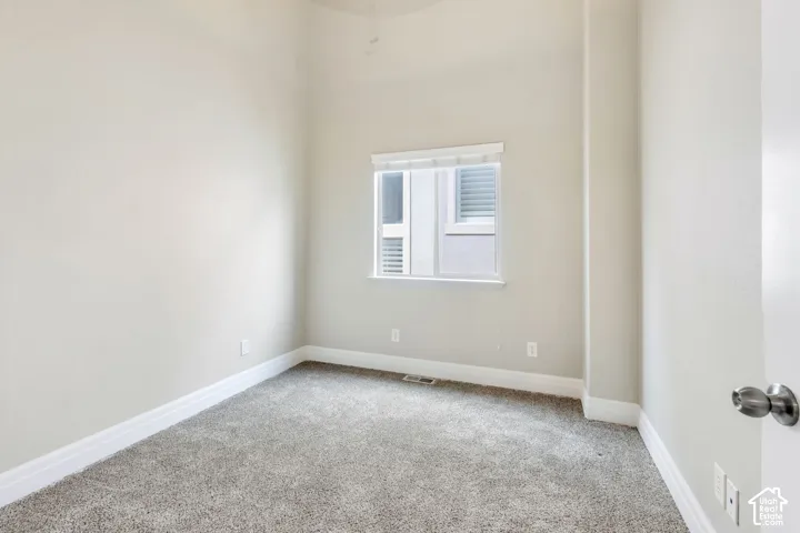 warm toned paint, beautiful carpet flooring, window with white blinds, white trim, and white painted door