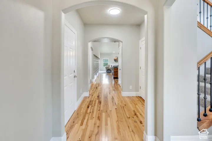 Entry Hallway featuring wood-finish flooring, an arched entryway, and a flush-mount ceiling light