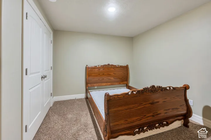 Basement Bedroom with Recessed ceiling lighting, neutral wall paint, white trim, and textured carpet flooring
