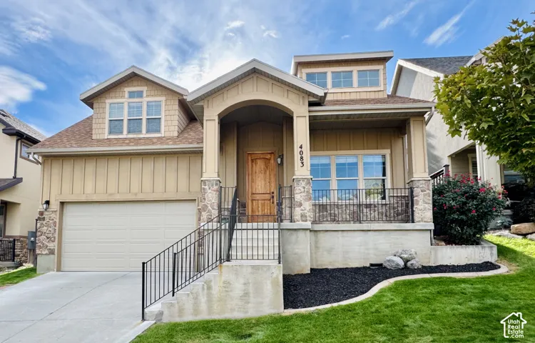Craftsman-style exterior with a covered porch, stone-wrapped columns, and a prominent wood entry door