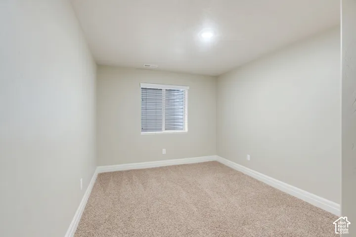 Basement Bedroom with Neutral wall paint, plush carpet flooring, recessed ceiling lighting, and a window with blinds