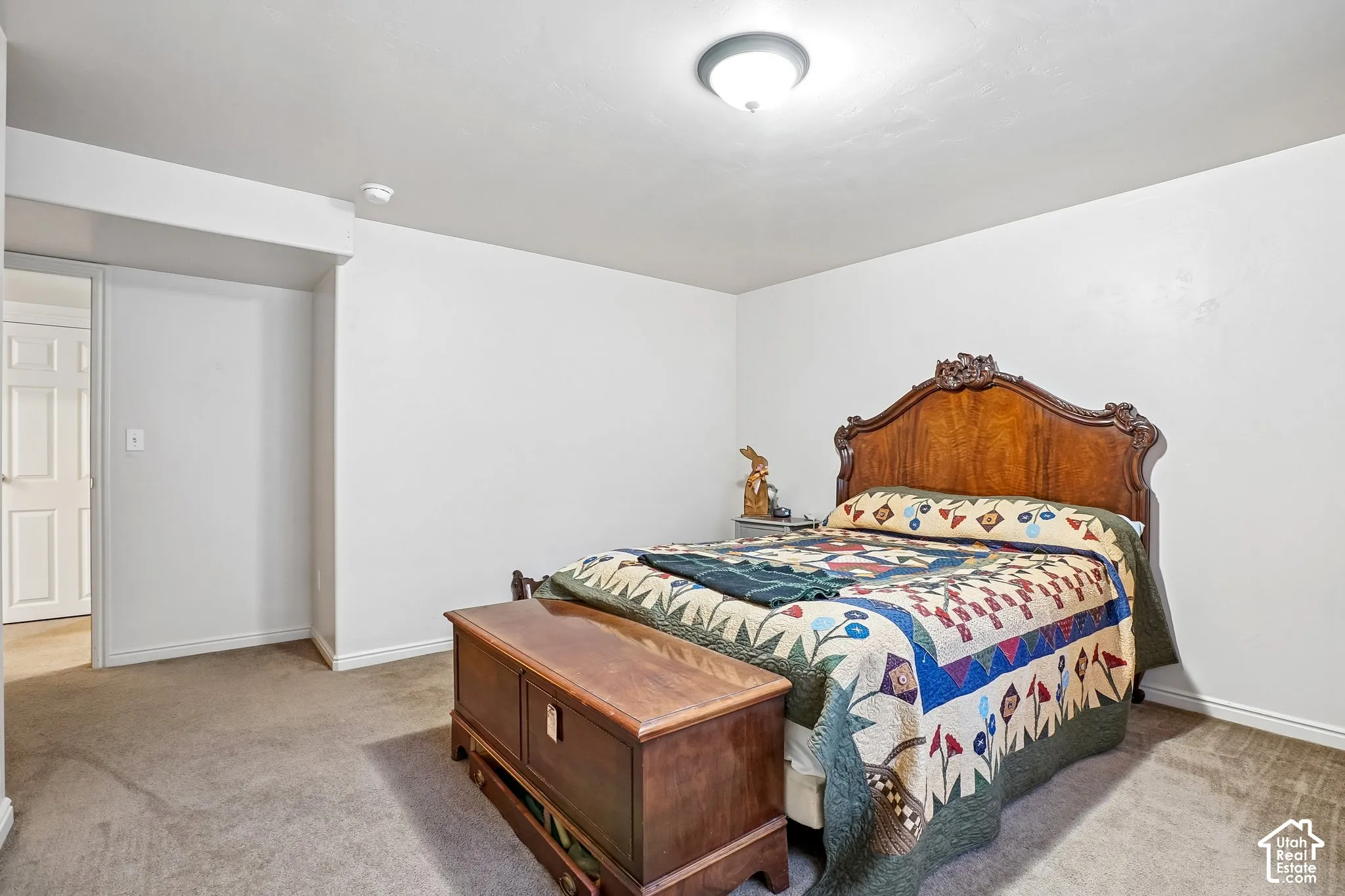 Wall-to-wall carpeting with light-colored walls and a classic wood door
