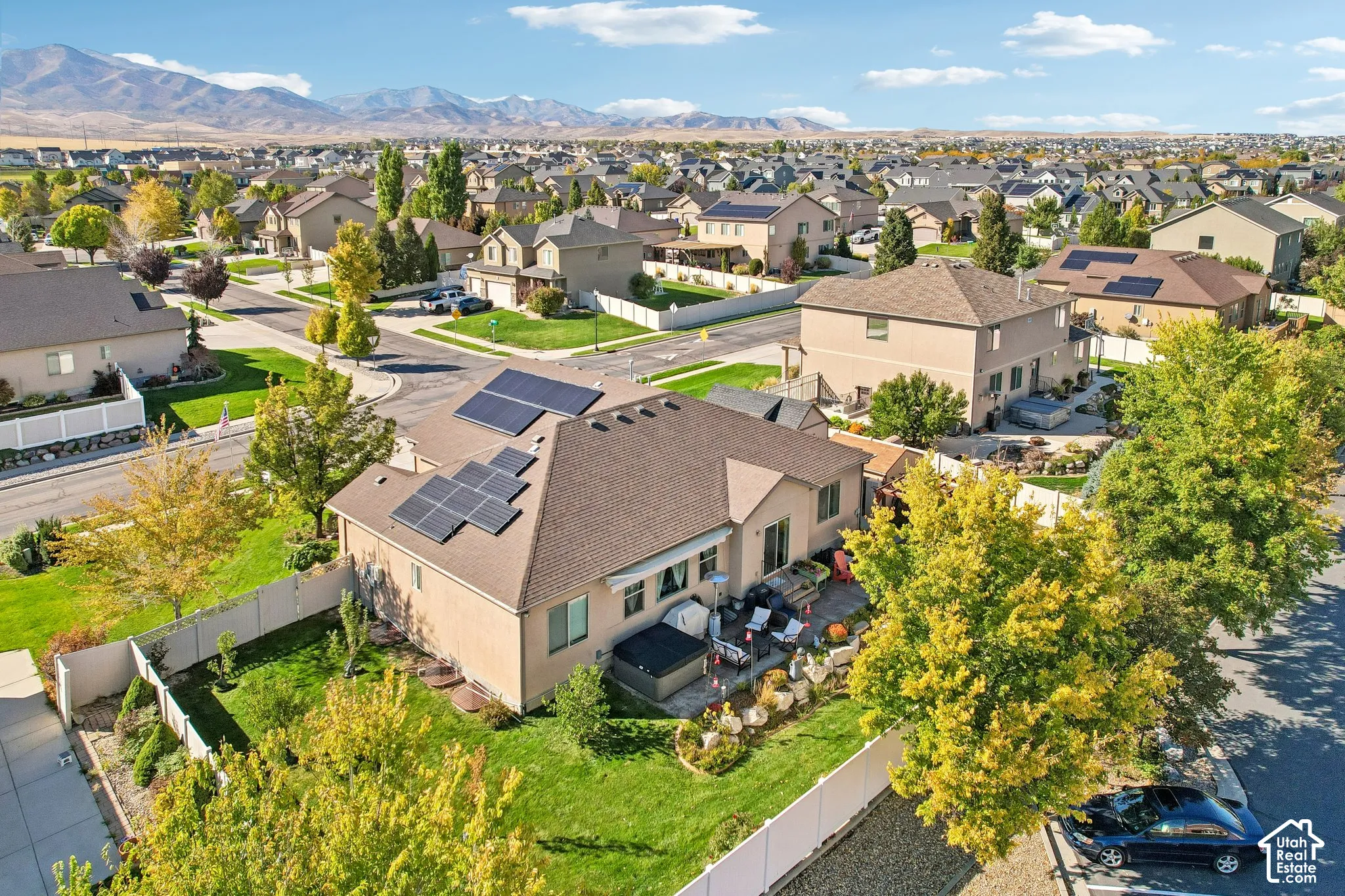 Rear property with solar panels, a manicured lawn, and a paved patio area