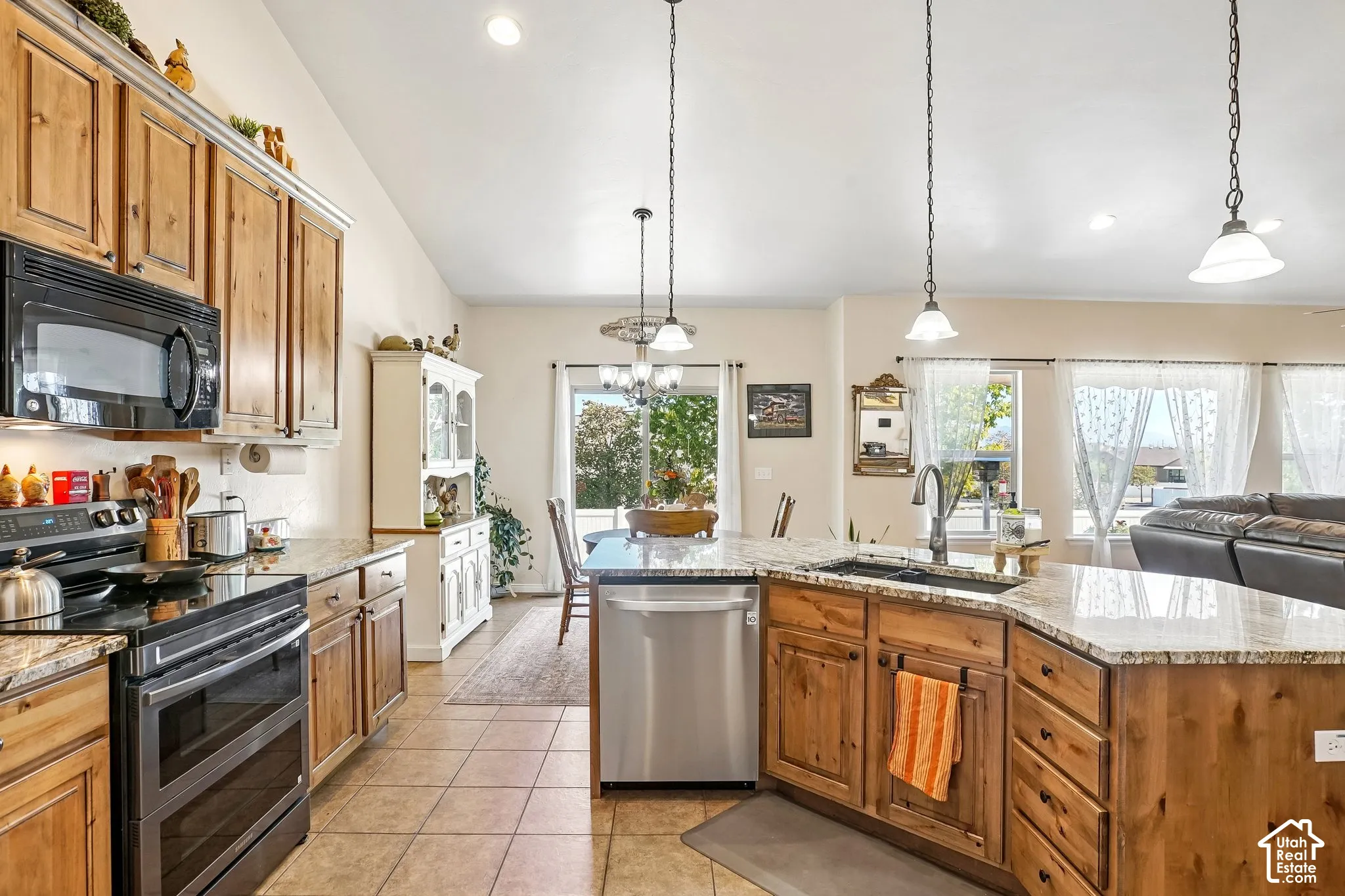 Kitchen featuring wood cabinetry, granite countertops, stainless steel appliances, and tile flooring