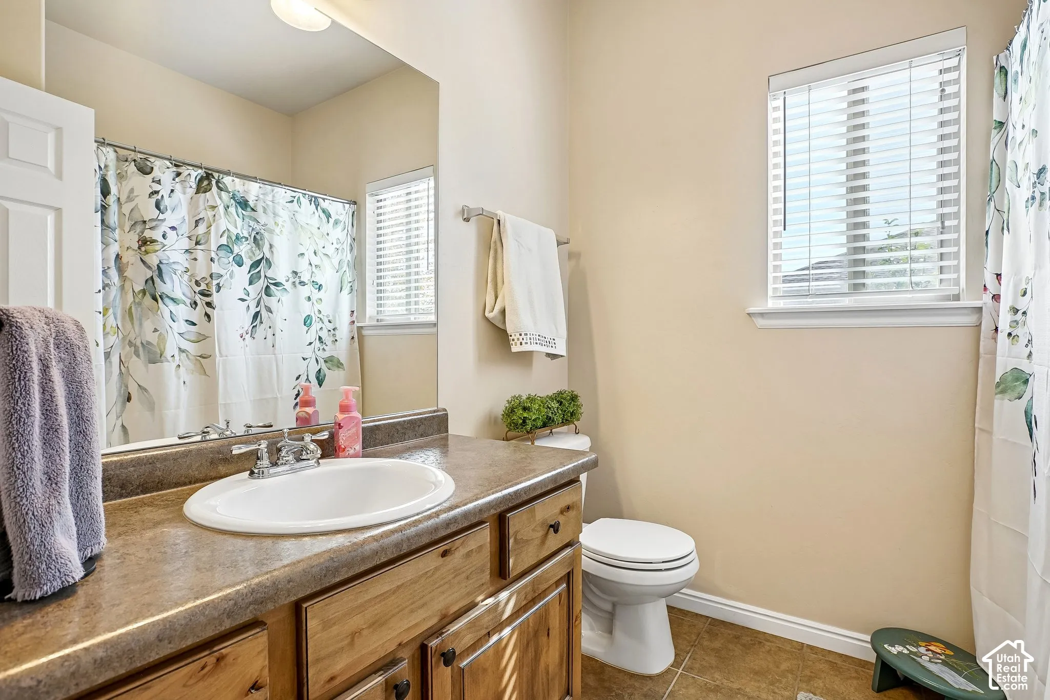 Full vanity with integrated sink, wood-finish cabinetry, and mirror