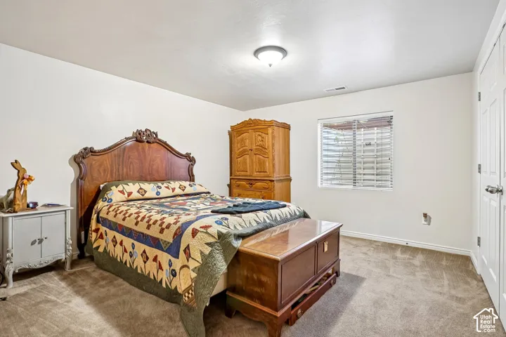 Carpeted flooring, recessed window with blinds, and a paneled door
