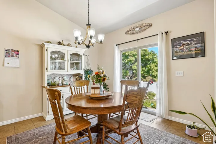 Dining area featuring a white built-in hutch, overhead chandelier, and a sliding glass door