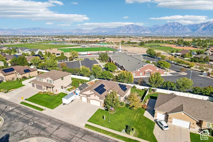 Mountain range backdrop, residential neighborhood setting, green playing fields, paved streets, and established landscaping