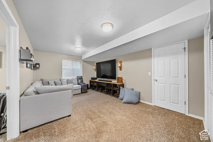 Carpeted room featuring recessed lighting, a window with blinds, and multiple doors