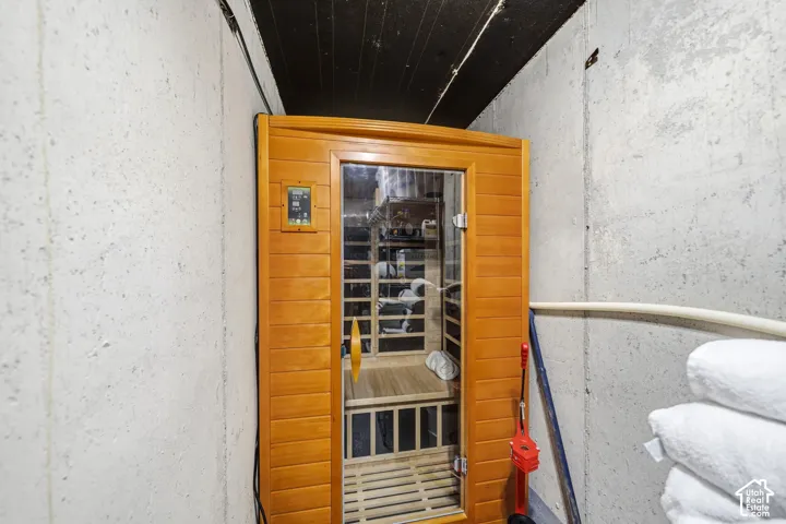 Wood-panel sauna with a glass door and control panel