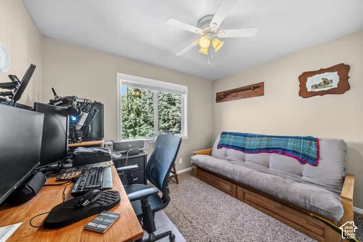 Carpeted interior space with a window, a ceiling fan, and light neutral wall paint