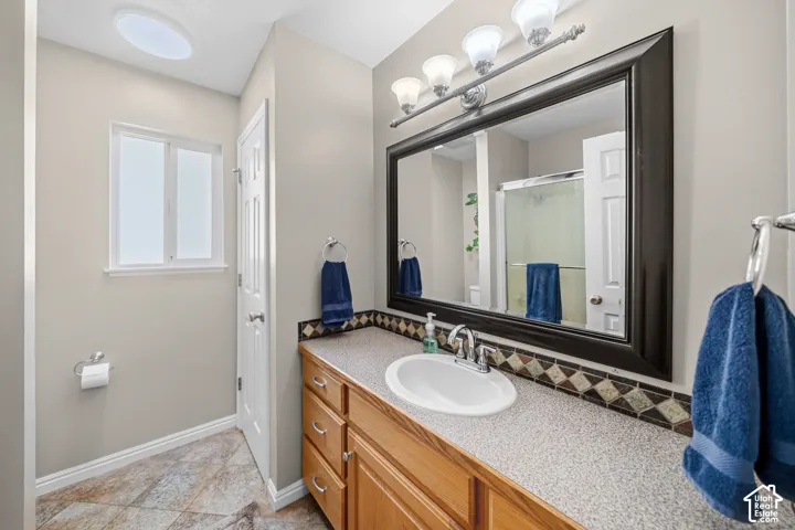 Wood-finish vanity with a white basin sink and chrome faucet