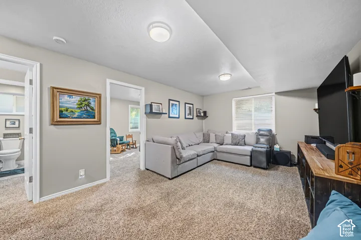 Recessed overhead lighting, light-toned carpeting, and a window with blinds