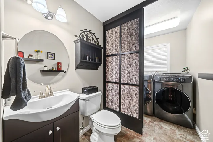 Bathroom featuring a vanity with an integrated sink, a circular mirror, and a sliding door