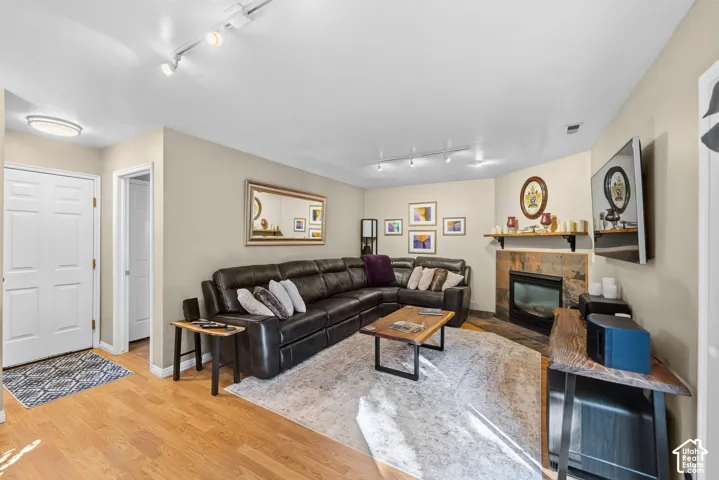 Wood-finish flooring throughout, track lighting, and a slate-surround fireplace with a wood mantle