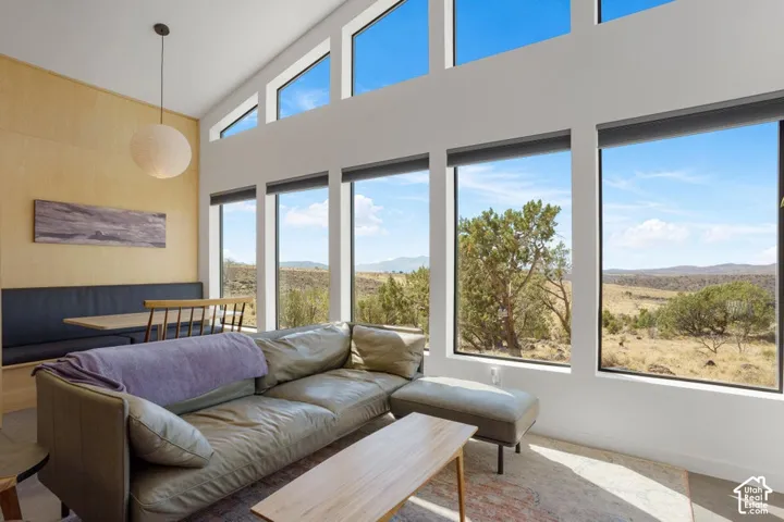Expansive windows with mountain and desert scenery, high ceilings, and a built-in banquette