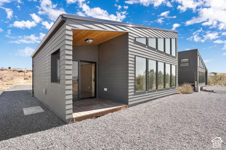 Modern construction featuring horizontal siding, extensive glazing, a wooden deck, and a wood-finish ceiling accent