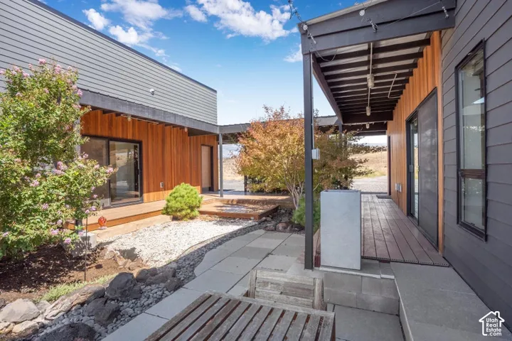 Modern exterior featuring horizontal wood siding and dark paneling, with a covered walkway and sliding glass doors