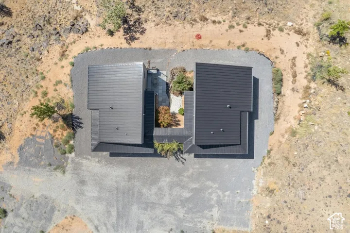 Two structures with dark metal roofs, gravel landscaping, and a central courtyard