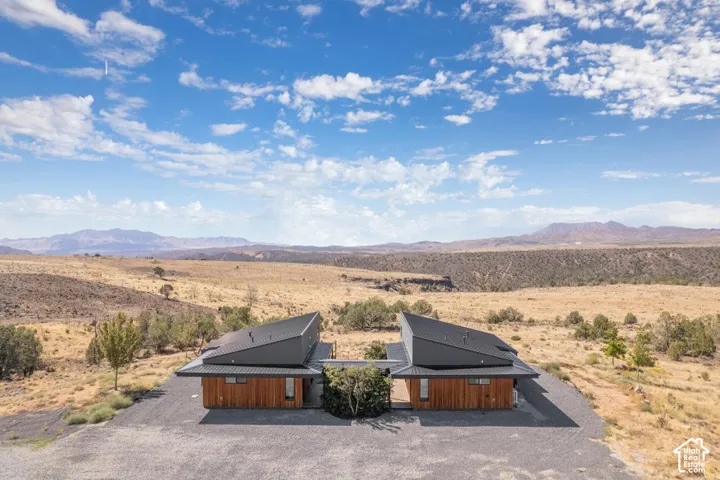 Modern architectural design featuring sloped roofs, wood-clad exteriors, and expansive gravel landscaping