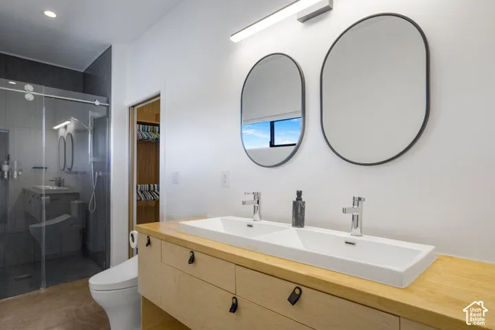 Dual vanity with a light wood-finish countertop, two rectangular sinks, and chrome faucets
