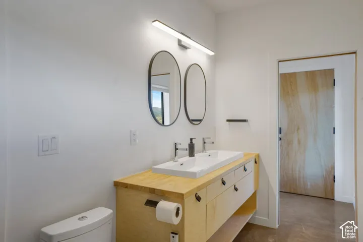 Light wood-finish vanity with an integrated rectangular double sink and dual faucets