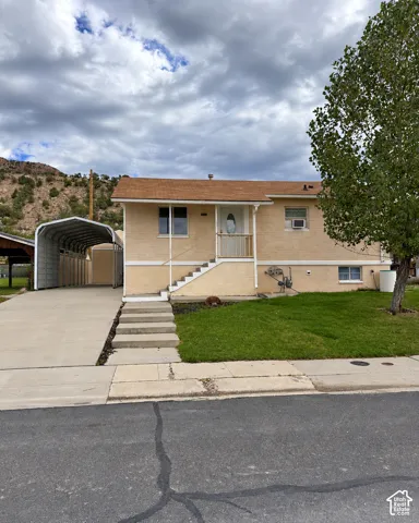 Brick exterior with a covered carport and concrete driveway