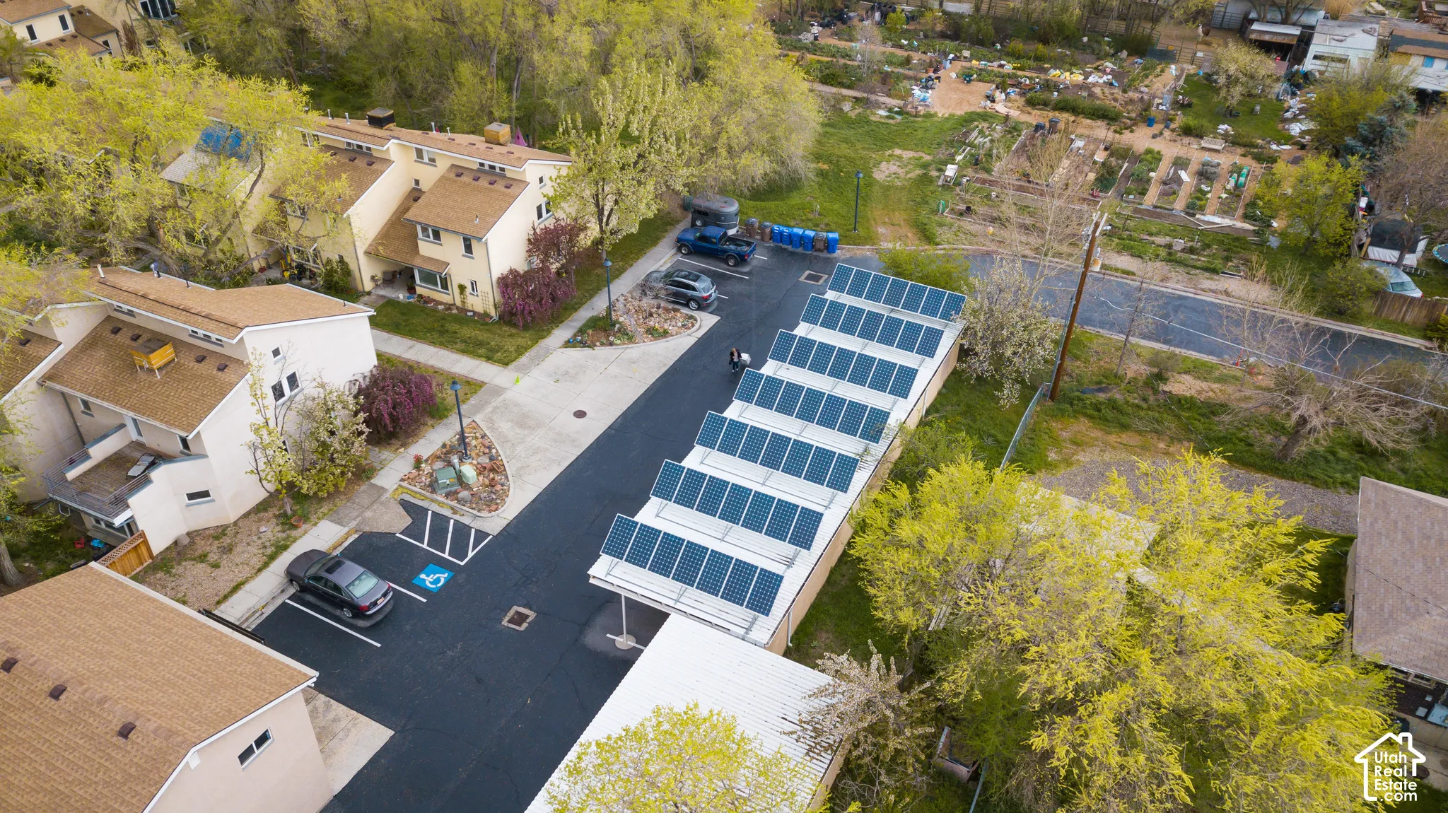 Exterior property featuring asphalt parking, a solar panel array, and a paved walkway
