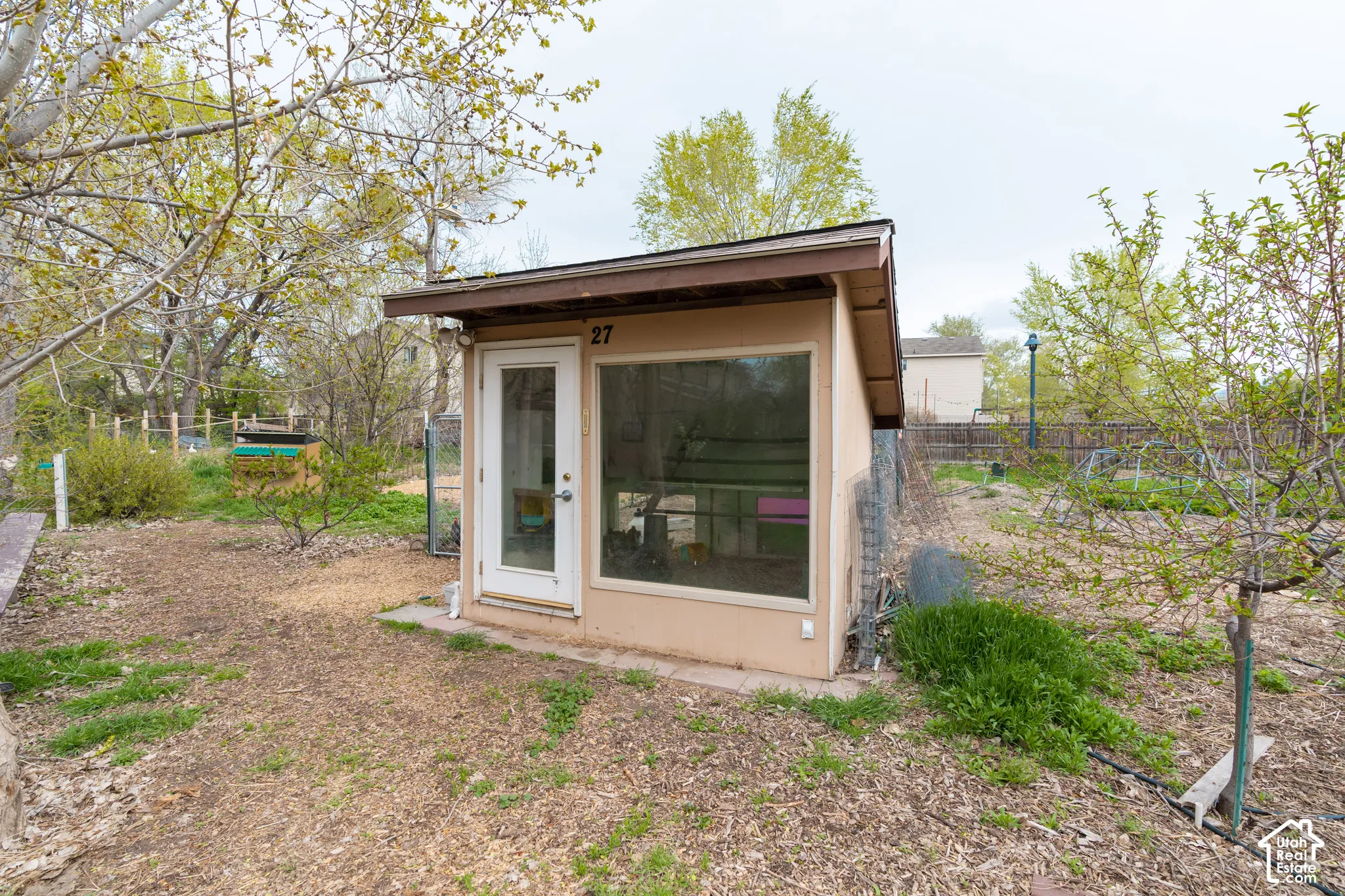 Detached accessory structure featuring a large fixed window and a glass-paneled entry door