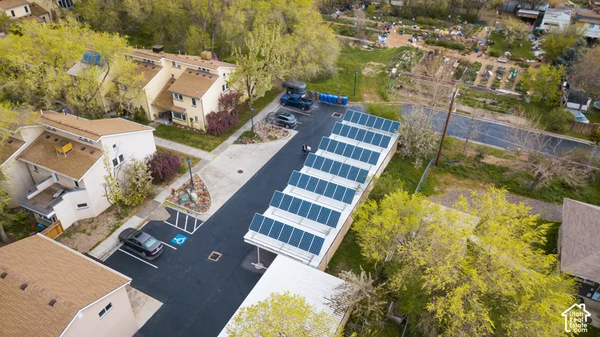 Exterior property featuring asphalt parking, a solar panel array, and a paved walkway