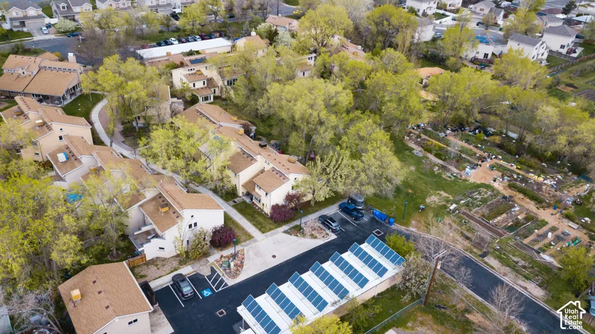 Residential complex with multiple buildings, paved parking areas, and mature trees