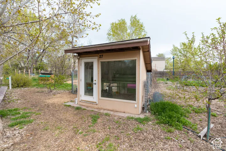 Detached accessory structure featuring a large fixed window and a glass-paneled entry door