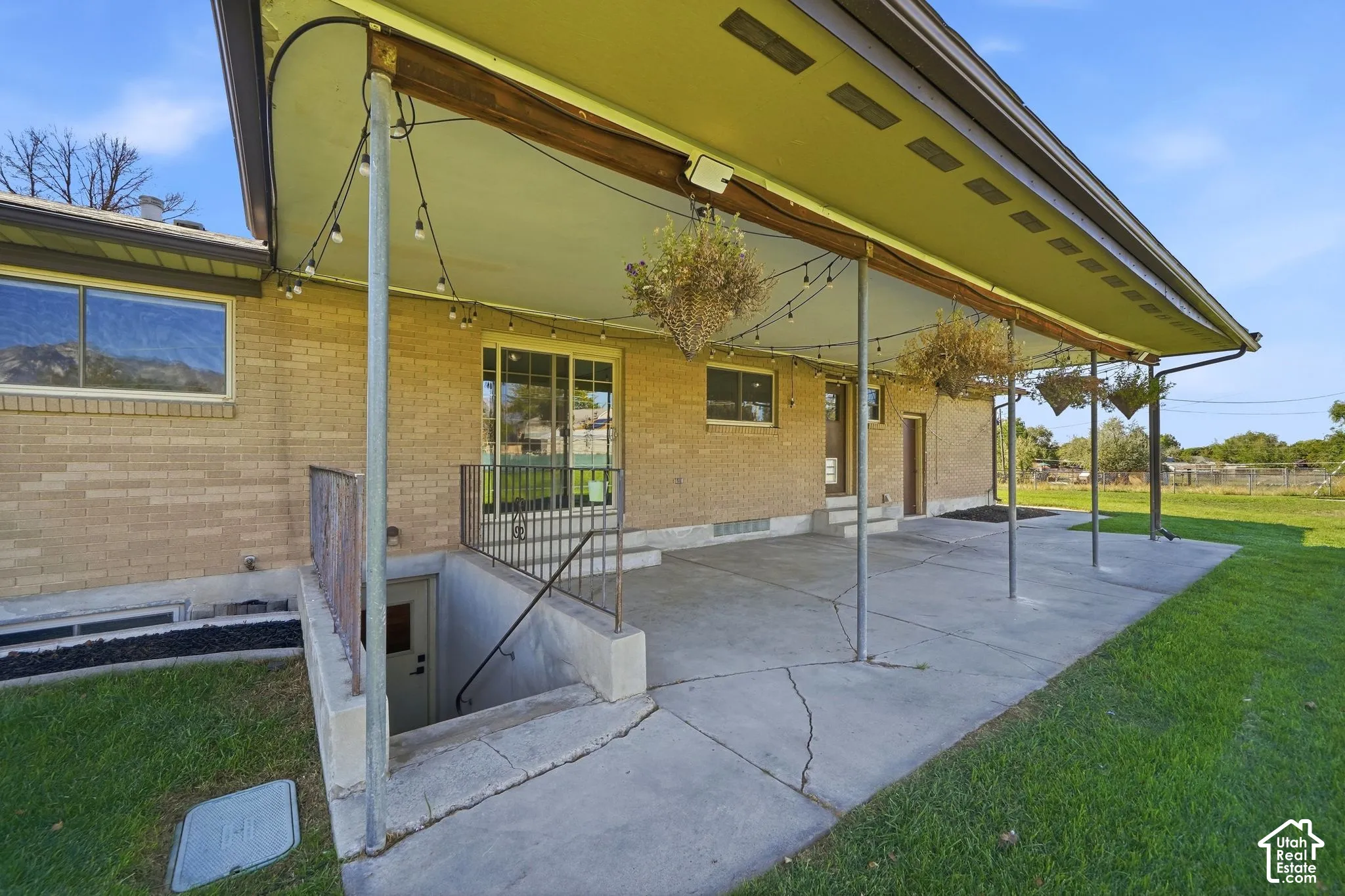 Brick exterior with covered patio, concrete surface, and sliding glass door access