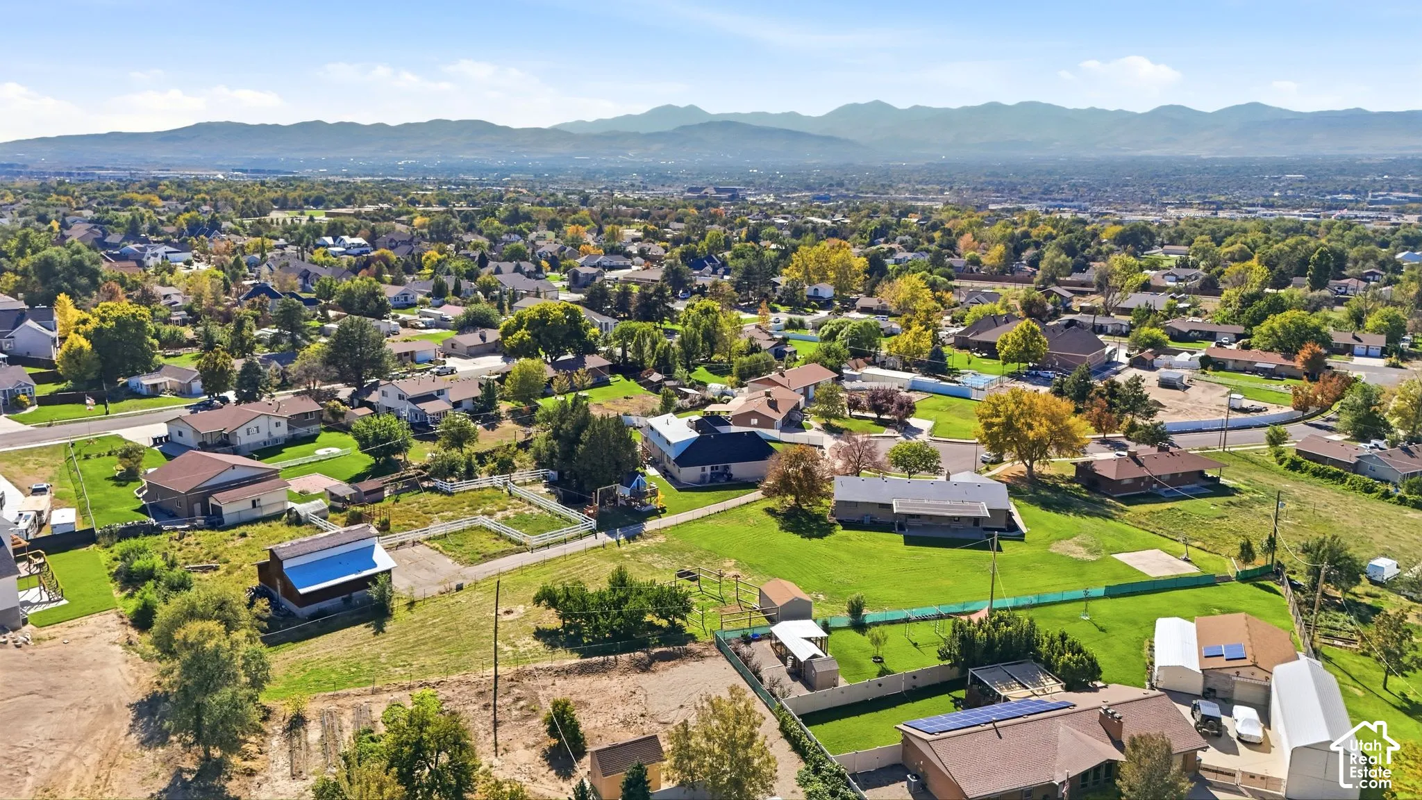 Expansive residential area featuring numerous single-family homes, mature trees, and distant mountain scenery