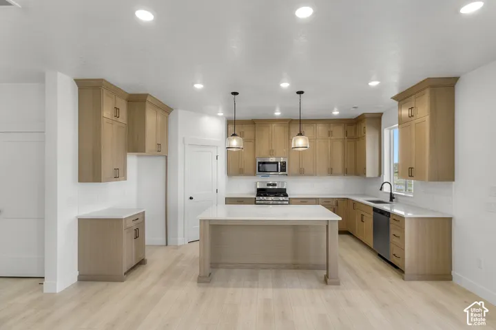 Kitchen featuring wood-finish cabinetry, stainless steel appliances, white subway tile backsplash, and a central island with a light-toned countertop