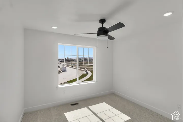 Recessed lighting, ceiling fan, and large window with grid pattern