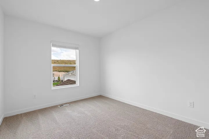 Carpeted flooring, white walls, white window trim, and white baseboards