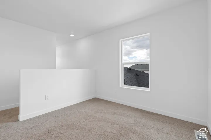 Carpeted flooring, white walls, recessed ceiling light, white window trim, and white baseboards